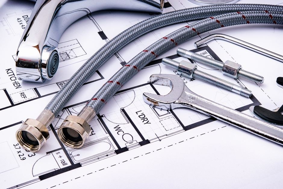 Architectural plans and measuring tools arranged on a work surface, illustrating a careful editorial process.