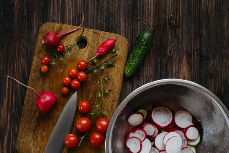 Fresh vegetables arranged on a wooden table for cooking.